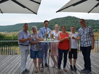 Weinprinzessin Laetitia Stockmeyer mit Landrat Florian Töpper (Mitte) bei der Prämierung der Landkreisweine 2023/24 in Handthal. Mit im Bild: Das Winzerehepaar Baumann (links) und die Winzerfamilie Groha (rechts), deren Weine aus dem Wettbewerb als Sieger hervorgingen. Foto: Melina Bosbach/Landratsamt Schweinfurt