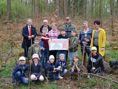 Das Foto (© Thomas Engert, Sparkasse) zeigt die Kinder der Mittagsbetreuung Ermershausen mit hinten von links: Vorstandsvorsitzender Peter Schleich, Bür- germeister Günter Pfeiffer, Revierleiter Jan Bergmann sowie den beiden Erzie- herinnen Evi Stühler und Ulrike Denninger