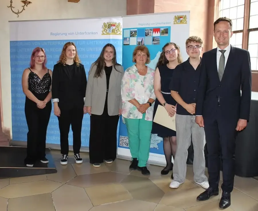 Landrat Florian Töpper gratuliert gemeinsam mit weiteren Gästen sechs Absolventinnen und Absolventen aus dem Landkreis Schweinfurt zur bestandenen Hauswirtschaftsprüfung.