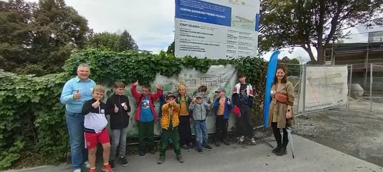 Kinder beim Ferienprogramm der ILE Mainschleife Plus 2025 während einer Baustellenführung am Freibad Volkach mit Betreuern.