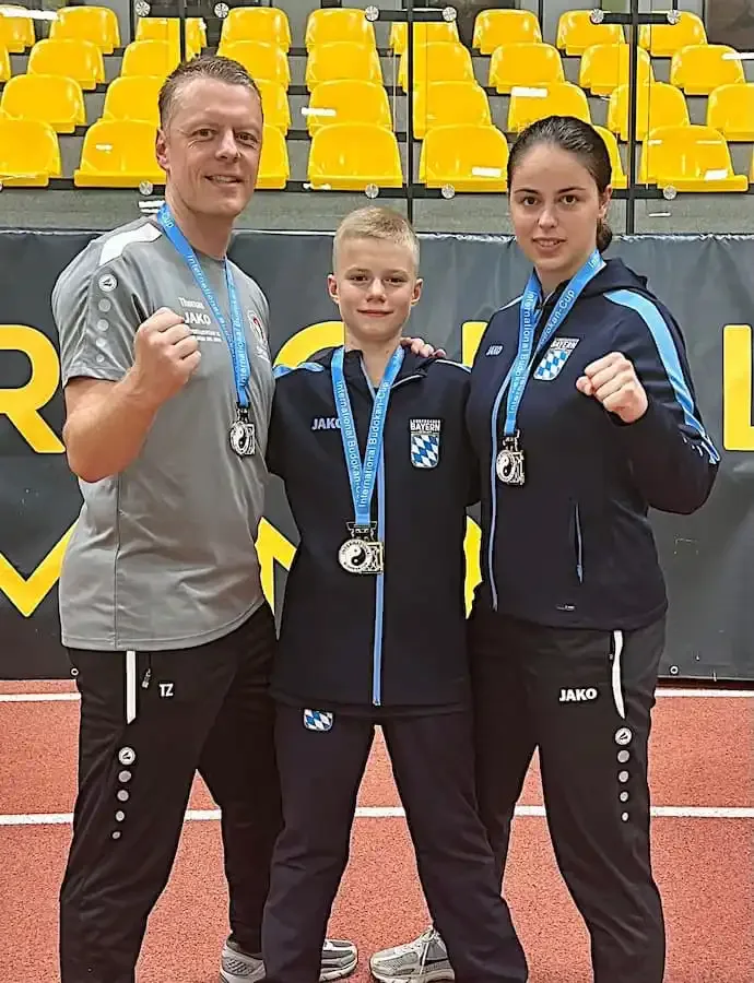 TG-Trainer Thomas Zatloukal mit Daniel Eckerdt und Hanna Rostiahai, alle mit Medaillen ausgezeichnet beim Karate-Turnier in Dortmund.