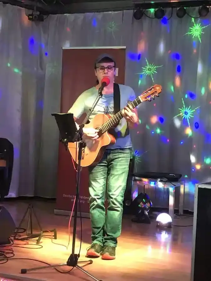 Liedermacher Yann Song King spielt mit Gitarre bei seinem Konzert in Schweinfurt 2025 auf der Bühne