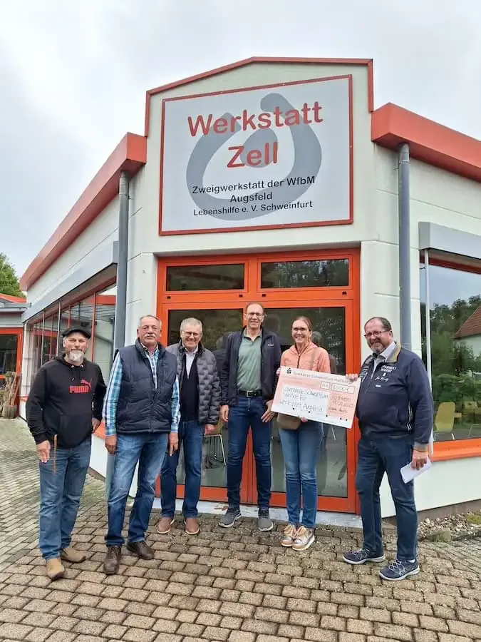 esal spendenuebergabe werkstatt zell lebenshilfe schweinfurt Spendenübergabe der ESAL Schaltanlagenbau GmbH vor der Werkstatt Zell der Lebenshilfe Schweinfurt – Gruppenfoto mit Scheck