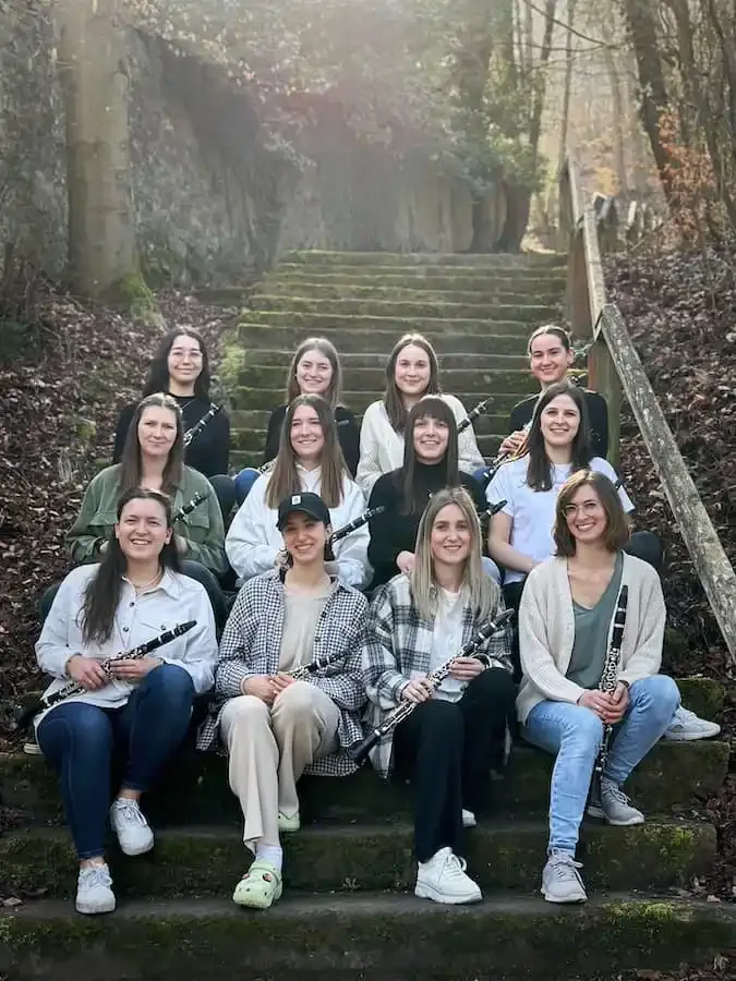 Mitglieder des Klarinettenregisters des Symphonischen Blasorchesters Volkach sitzen auf einer Treppe im Freien und freuen sich auf den Ensemble-Herbst in Dimbach und Gaibach.