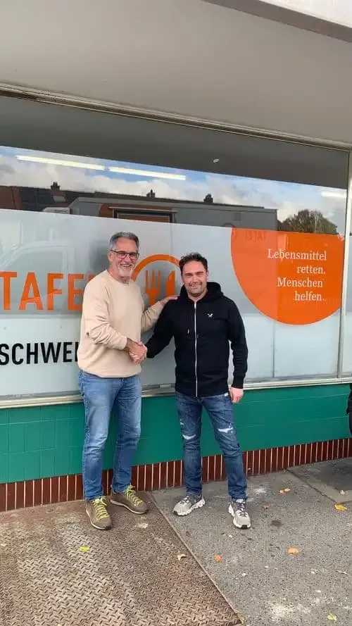 Sebastian Walz überreicht eine 1.000-Euro-Spende an Ernst Gehling von der Tafel Schweinfurt vor dem Tafelladen in Schweinfurt.