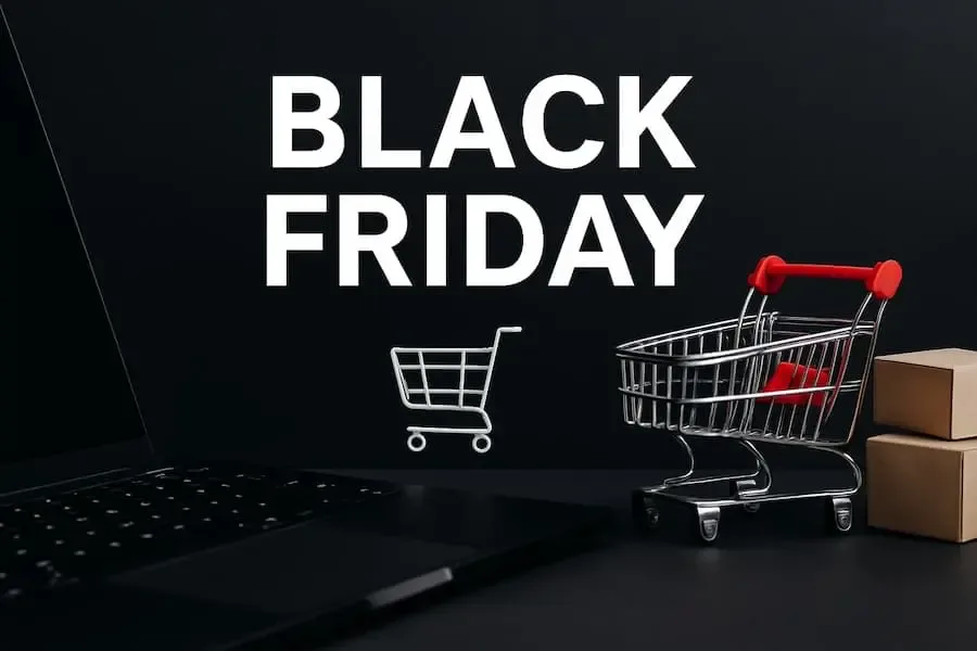 Black-Friday-Motiv mit Einkaufswagen, Laptop und Paketen vor dunklem Hintergrund als Symbol für Rabatte und Online-Shopping.