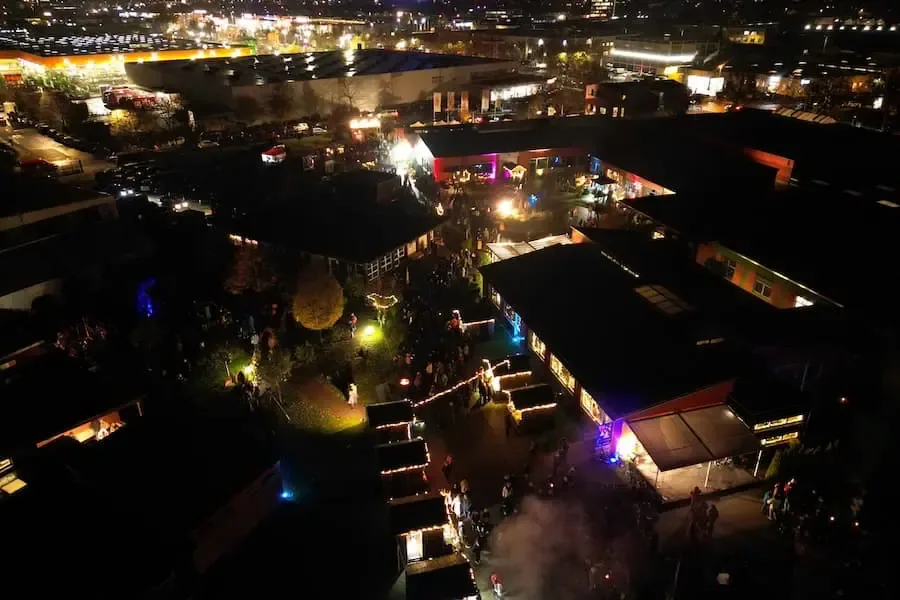 Luftaufnahme der Lichternacht „anders schön“ der Lebenshilfe-Werkstatt Sennfeld bei Nacht mit beleuchtetem Adventsmarkt und vielen Besuchern
