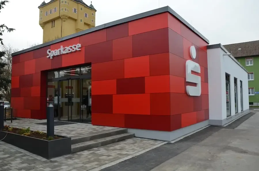 sparkasse bergl neueroeffnung aussenansicht 2025 Außenansicht der modernisierten Sparkassenfiliale am Bergl mit roter Fassadengestaltung.