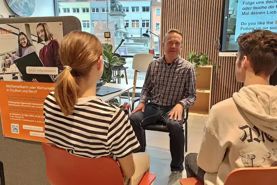 Beratungssituation in der StudyFAB Schweinfurt: Studierende im Gespräch mit einem Experten im kreativen Begegnungsraum in der Keßlergasse.