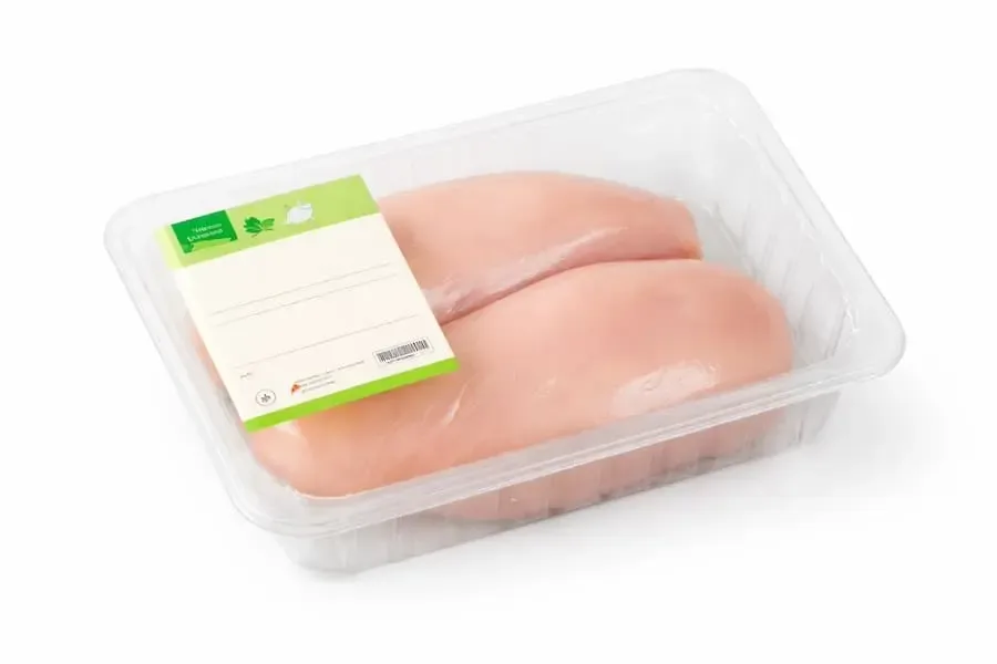 Abgepacktes rohes Hähnchenbrustfilet in transparenter Kunststoffverpackung als neutrales Symbolbild