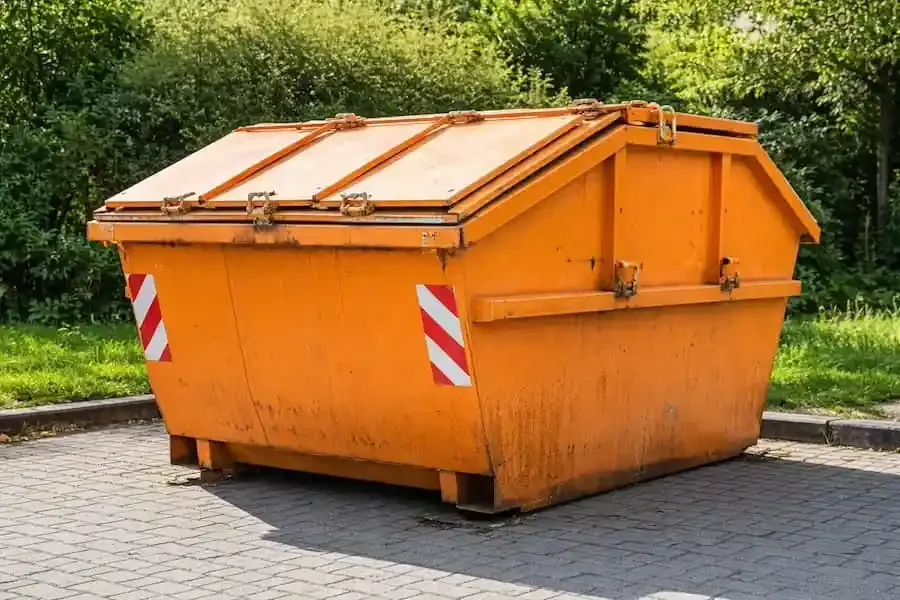 Oranger Müllcontainer als Symbol für illegale Müllablagerungen an Wertstoffcontainern in Schweinfurt