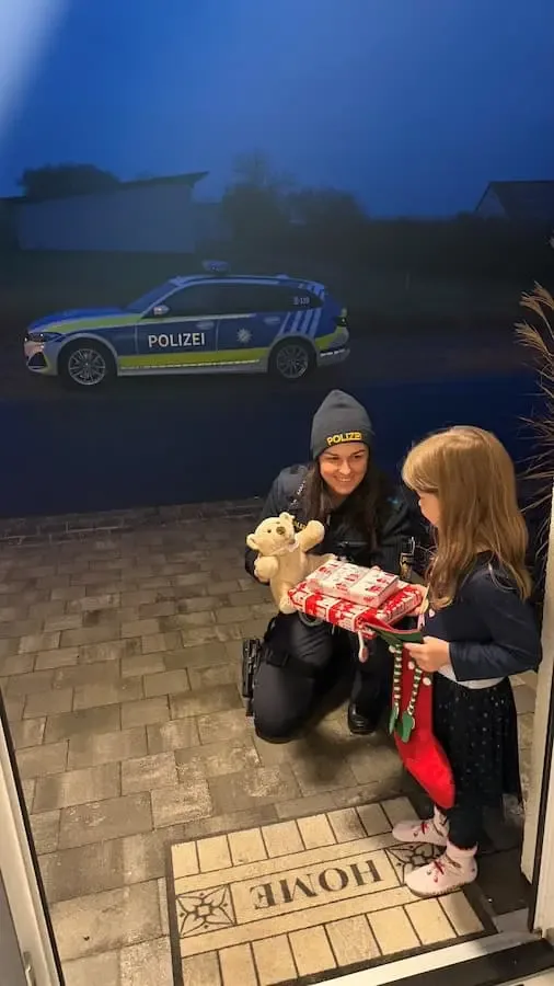 Polizeistreife übergibt einem Kind eine Nikolaustüte vor einem Wohnhaus in Zeuzleben.