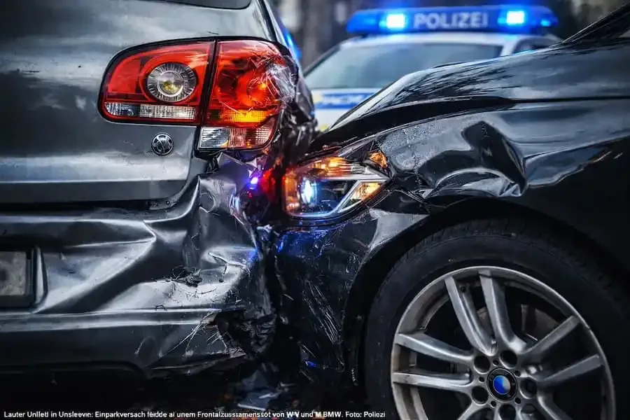 Beschädigte Fahrzeuge nach einem Verkehrsunfall in Unsleben, im Hintergrund ein Streifenwagen der deutschen Polizei mit Blaulicht