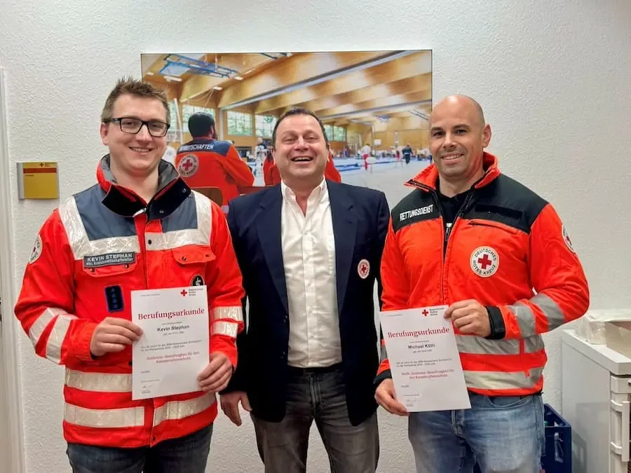 Kevin Stephan und Michael Köth mit BRK-Vorsitzendem Holger Merz bei der Berufung für den Katastrophenschutz in Schweinfurt.