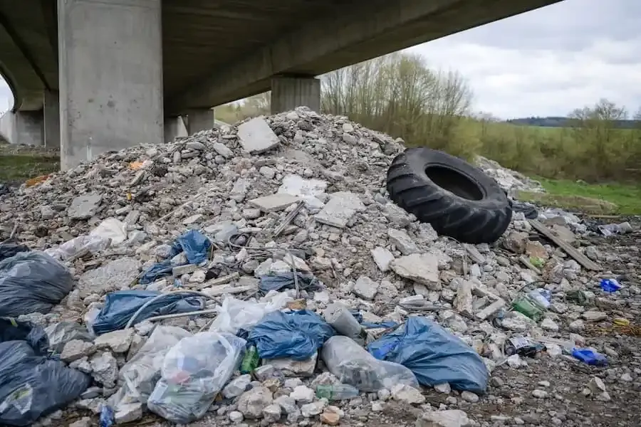 Illegale Müllablagerung mit Bauschutt unter Autobahnbrücke der A71 bei Poppenhausen im Landkreis Schweinfurt