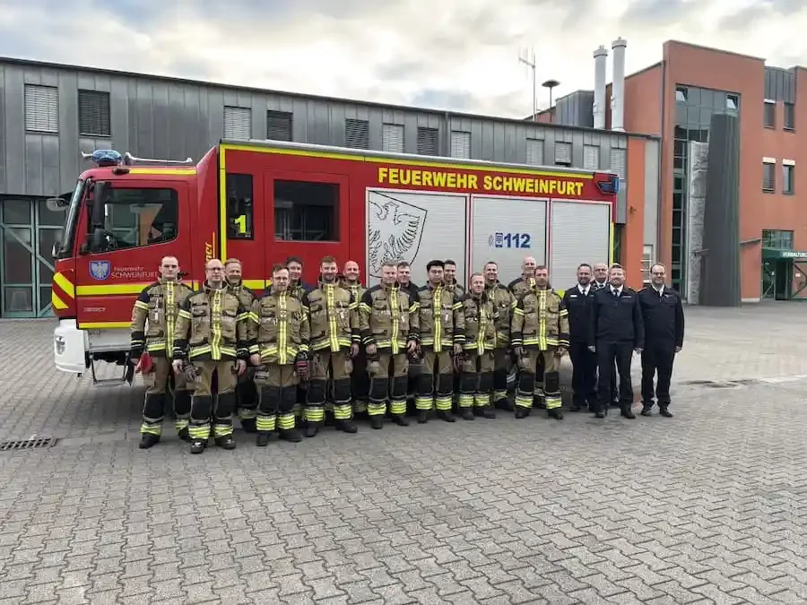 Einsatzkräfte der Freiwilligen Feuerwehr Schweinfurt nach bestandener Leistungsprüfung Technische Hilfeleistung vor einem Feuerwehrfahrzeug.