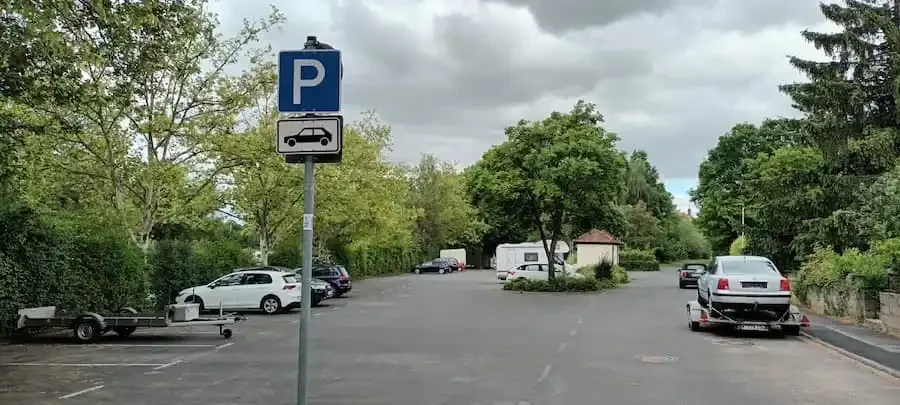 Parkplatz am Kirchbergweg in Volkach mit abgestellten Fahrzeugen und Anhängern.