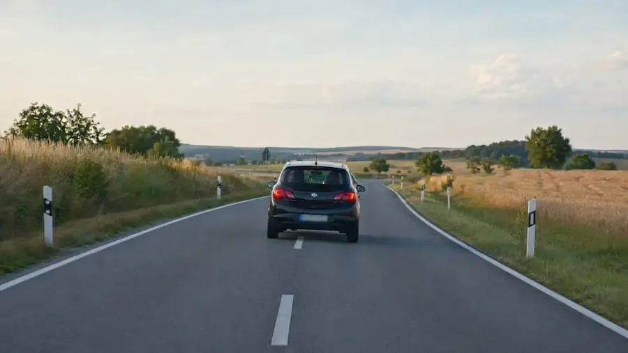 Schwarzer Kleinwagen fährt auf der B303 bei Euerbach über die Fahrbahnmitte