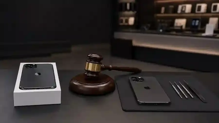Zwei Apple-Smartphones neben einem Richterhammer und Reparaturwerkzeug