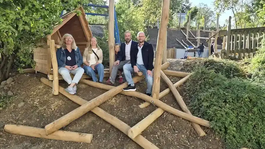 Ulrike Büx-Rudolph, Valentina Friedrich mit Sohn Johannes, Bürgermeister Stefan Rottmann und Stefan Roßkopf auf einem Spielgerät der Kita Schonungen.