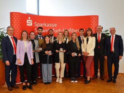 Das Foto „Absolventen Ausbildung“ (© Birgit Kraus) zeigt von links nach rechts: Vorstandsvorsitzender Peter Schleich, Isabell Döpfner, Melike Cihan, Mehmet Tatli, Tanja May, Mansur Korkmaz, Vanessa Geyer, Anne Mahlmeister, Joelle Görner, Lukas Fries, Ausbildungsleiterin Anja Prochaska, sowie die Vorstandsmitglieder Andreas Linder und Roberto Nernosi