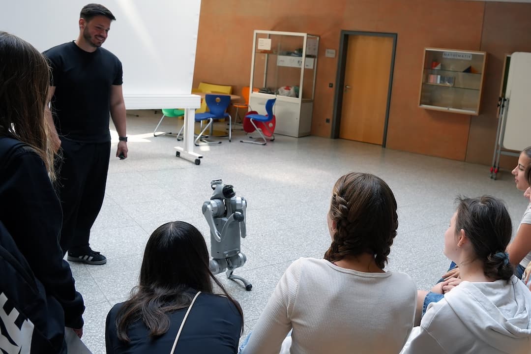 THWS‐Doktorand Marvin Tessitore, Fakultät Informatik und Wirtschaftsinformatik (li.), stellt Schülerinnen und Schülern der achten Klassen des Gymnasiums Veitshöchheim einen Roboter‐Hund als Highlight des Leitbildtags vor (Foto: THWS/Anne Speda)