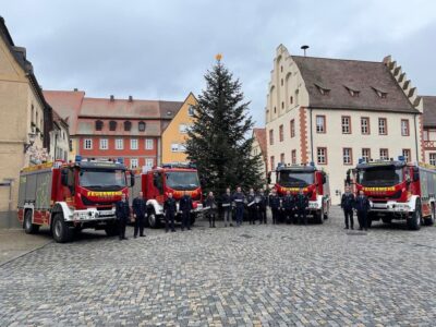 Die Führungsriegen der Feuerwehren Schwanfeld, Gerolzhofen, Schonungen und Unterspiesheim bei der Fahrzeugübergabe auf dem Marktplatz Gerolzhofen mit Oberregierungsrätin Sonja Weidinger (Leiterin Abteilung Öffentliche Sicherheit und Ordnung), Landrat Florian Töpper, Florian Zippel (Arbeitsbereichsleiter Katastrophenschutz und Feuerwehrwesen), Kreisbrandrat Holger Strunk, Kreisbrandinspektor und designierter Kreisbrandrat Alexander Bönig sowie Kreisbrandinspektor Andreas Schraut. Foto: Andreas Lösch/Landratsamt Schweinfurt