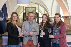 Auf einen Silvaner in der Vinothek des Weinguts Juliusspital Würzburg: Antonia Kraiß, Weingutsdirektor Joachim Brand, 66. Fränkische Weinkönigin Lisa Lehrittter und Vanessa Nüßlein (v. l. n. r.). Foto: Rudi Merkl / Gebietsweinwerbung Frankenwein-Frankenland GmbH