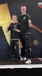 Foto: von Liudmila Eckerdt. Daniel Eckerdt (links) von der TG Schweinfurt mit der Goldmedaille in der Open-Kategorie beim Internationalen Arawaza-Cup in Halle (Saale) mit Trainer Thomas Zatloukal (rechts)