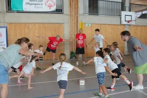 Die Helfer und Betreuer zeigen die durch einen Würfel vorgegebene Bewegung und die Kinder ahmen sie mit Freude nach.