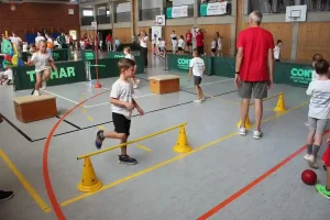 Abbildung Parcours: Die Kinder durchlaufen mit viel Begeisterung zusammen mit freiwilligen Helfern den Bewegungs-Parcours.