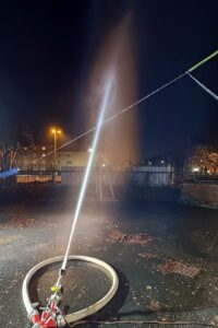Unbemannter Wasserwerfer mit Vollstrahl auf das unter Spannung stehende Leiterseil (Foto: THWS/Markus Zink)