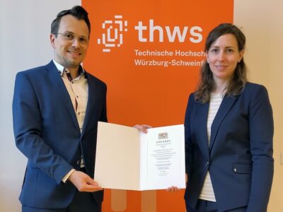THWS-Präsident Prof. Dr. Jean Meyer überreicht die Ernennungsurkunde an die neuberufene Stiftungsprofessorin Prof. Dr.-Ing. Lisa Kiesewetter (Foto: THWS/Martin Kraus)