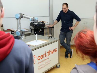 Erst programmieren, dann den Roboter malen lassen – Prof. Dr. Andreas Makowski erklärt, wie filigrane Fraktale auf dem Papier entstehen (Foto: THWS/Jürgen Schwittek)