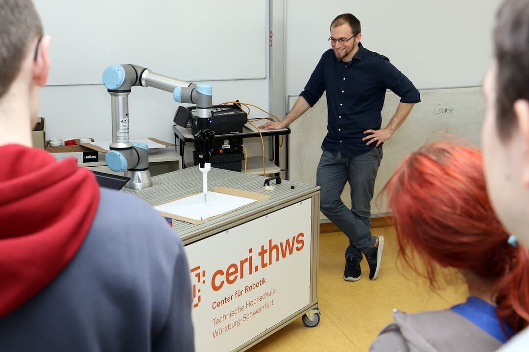 Erst programmieren, dann den Roboter malen lassen – Prof. Dr. Andreas Makowski erklärt, wie filigrane Fraktale auf dem Papier entstehen (Foto: THWS/Jürgen Schwittek)
