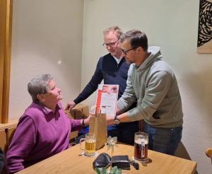 v.l.n.r.: Maria Geyer (sitzend) wird geehrt von 1. Vorsitzenden Christian Lutz und 2. Vorsitzenden Clemens Laugsch