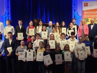 Unser Foto zeigt die strahlenden Preisträger/innen mit Landrätin Tamara Bischof und dem Juryvorsitzenden Prof. Ernst Oestreicher. Foto: Landratsamt Kitzingen