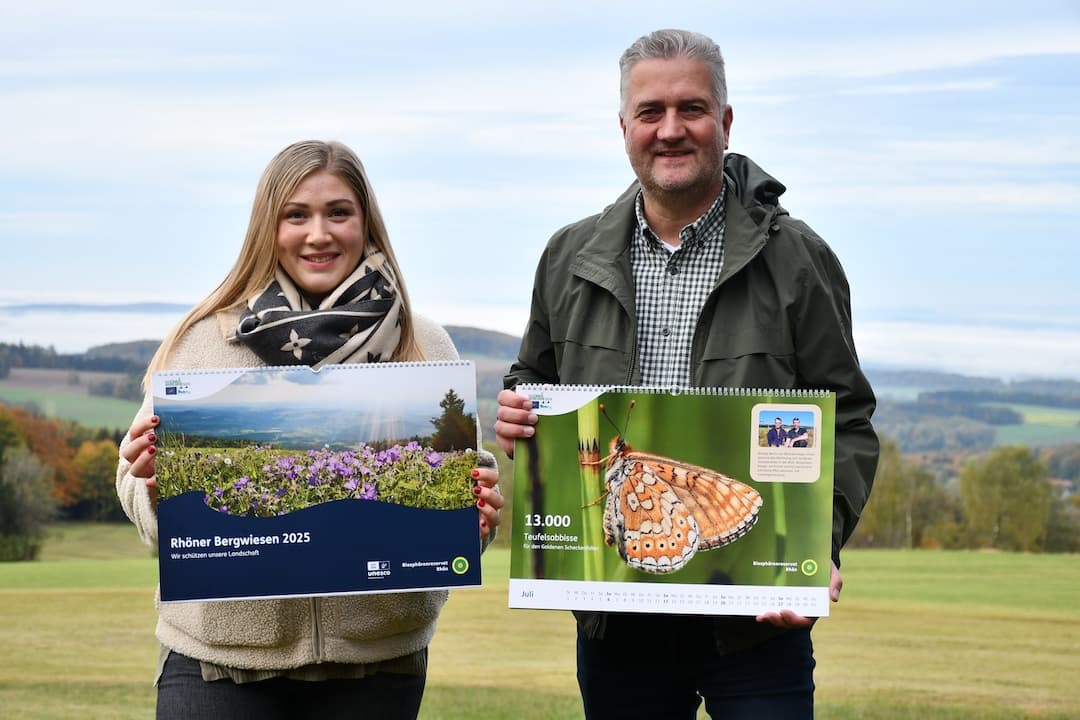 LIFE-Projektleiterin Katharina Bach und Torsten Raab, Leiter der Hessischen Verwaltungsstelle des UNESCO-Biosphärenreservates Rhön, präsentieren den neuen Bergwiesen-Wandkalender. Foto: Lea Hohmann