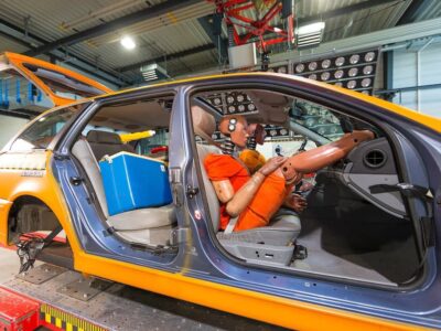 Vorbereitungen Crashtest mit Füßen des Dummy auf dem Armaturenbrett, Quelle: ©ADAC/Axel Griesch