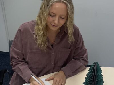 Vera Ksinski beim Schreiben einer Weihnachtskarte. Foto: Kathrin Glaubrecht.