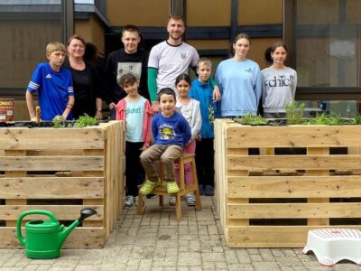 (Foto Calvin Gehret): Zwei Kräuterhochbeete für das Kinderheim in Geesdorf: Nach getaner Arbeit blicken die Auszubildenden von Kräuter Mix zusammen mit den Jungen und Mädchen zufrieden auf ihr Werk.