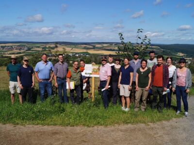 Gruppenfoto mit Blick auf das neue Wildlebensraummodellgebiet Mönchberg mit dem Bürgermeister von Mönchberg Bernd Wetzel (3.v.l.) und Eberhard Heider (5.v.l.) (Foto: Franziska Schorr, LWG)